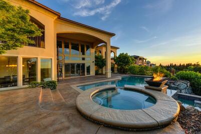 A home with a pool and a stamped concrete pool deck. 